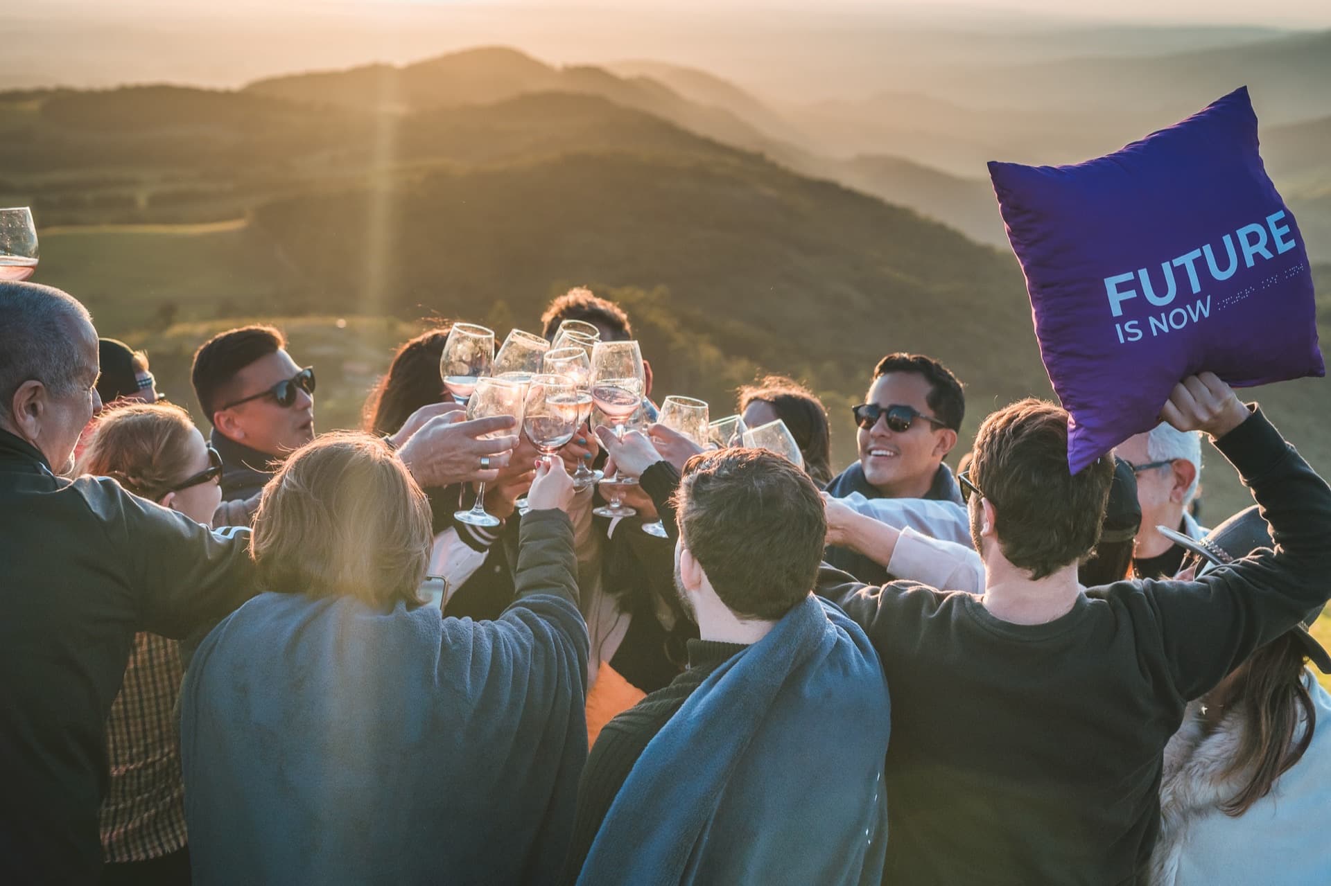 Brinde coletivo com vista para as montanhas ao entardecer